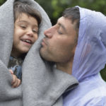 Refugees on their way to western Europe, a man from Iran holds his son as they approach the border into Croatia near the Serbian village of Berkasovo. The ACT Alliance has provided critical support for refugee and migrant families here and in other places along their journey.
